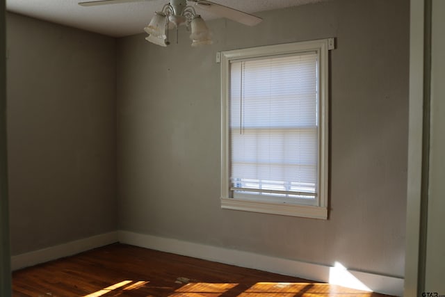 unfurnished room with dark hardwood / wood-style flooring and ceiling fan