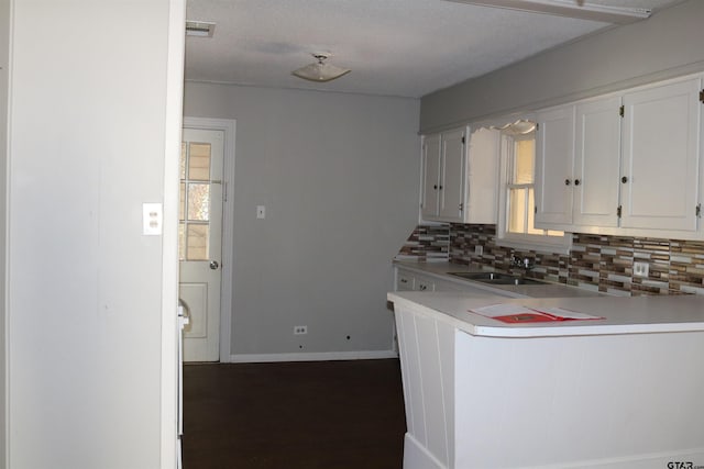 kitchen featuring white cabinets, decorative backsplash, sink, and a textured ceiling