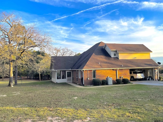 exterior space featuring a front lawn, a sunroom, cooling unit, and a carport