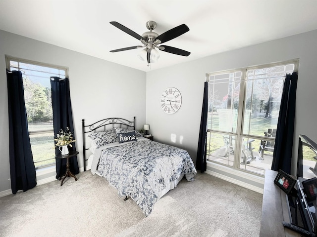 carpeted bedroom featuring multiple windows and ceiling fan