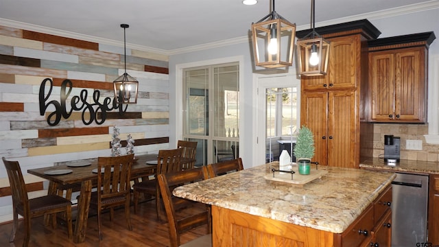 kitchen with pendant lighting, a center island, light stone countertops, and ornamental molding