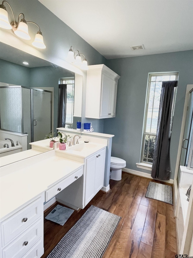 full bathroom featuring hardwood / wood-style floors, toilet, vanity, and plus walk in shower