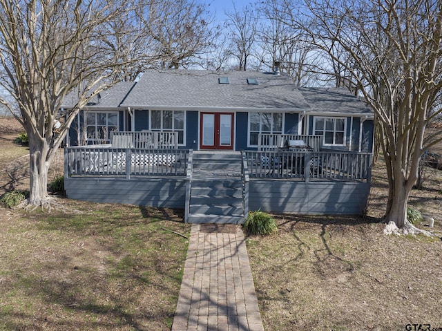 ranch-style house featuring french doors, a shingled roof, and a wooden deck