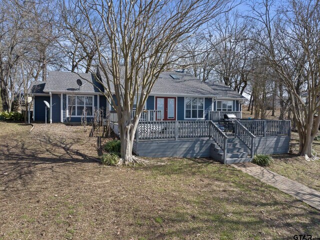 ranch-style house with roof with shingles and a wooden deck
