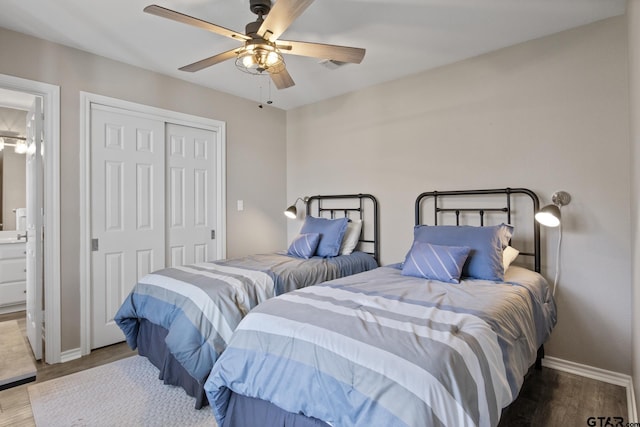 bedroom featuring a closet, visible vents, baseboards, and wood finished floors