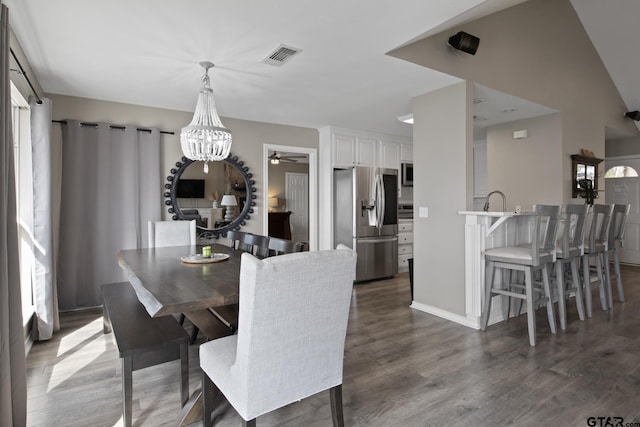 dining space featuring a notable chandelier, visible vents, and wood finished floors