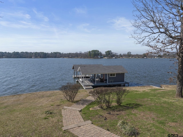 view of dock with a yard and a water view