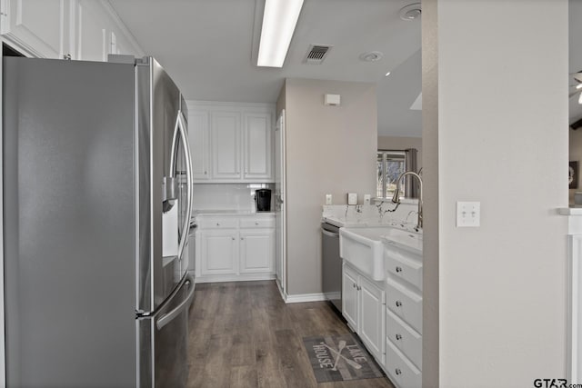 kitchen featuring stainless steel appliances, visible vents, white cabinetry, backsplash, and dark wood finished floors
