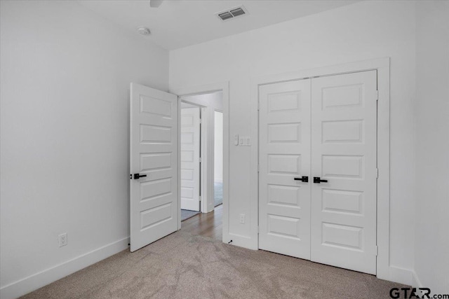 unfurnished bedroom featuring a closet, carpet, visible vents, and baseboards