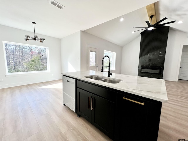 kitchen featuring visible vents, dishwashing machine, open floor plan, dark cabinets, and a sink