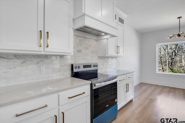 kitchen with premium range hood, decorative backsplash, white cabinets, and stainless steel range with electric cooktop