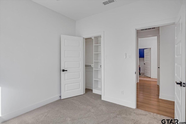 unfurnished bedroom with carpet floors, baseboards, and visible vents