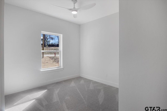 carpeted empty room featuring baseboards and a ceiling fan