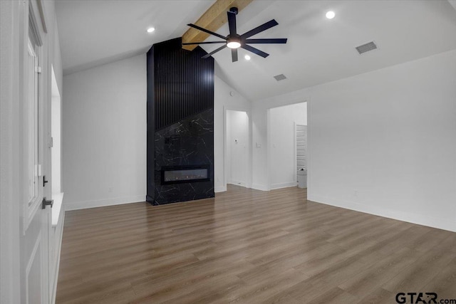 unfurnished living room with visible vents, a ceiling fan, wood finished floors, beam ceiling, and a high end fireplace