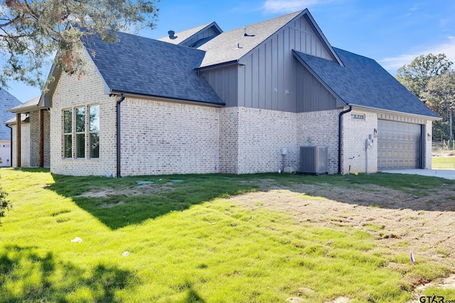 view of side of home with a garage, central AC, and a lawn