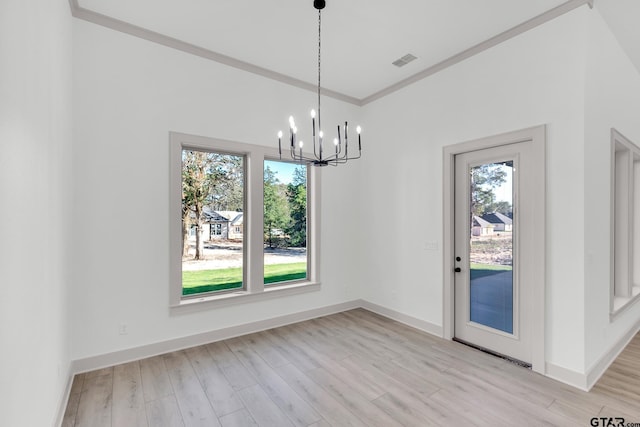 unfurnished dining area featuring light wood-type flooring, an inviting chandelier, and ornamental molding