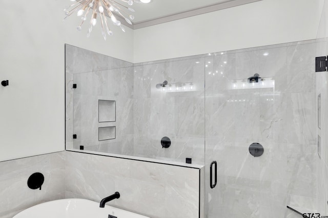 bathroom featuring a notable chandelier and shower with separate bathtub