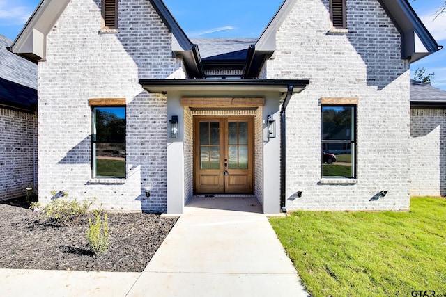 property entrance with french doors and a lawn