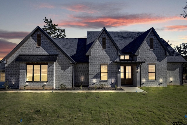 view of front of house with a lawn and french doors