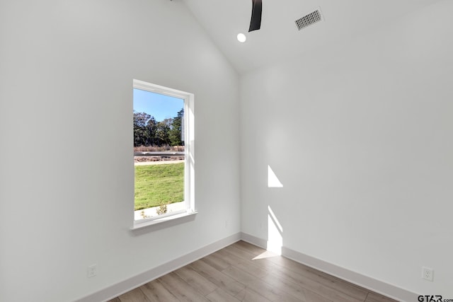 empty room featuring high vaulted ceiling, ceiling fan, a wealth of natural light, and light wood-type flooring