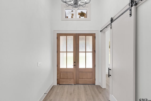 entryway featuring light hardwood / wood-style floors, plenty of natural light, a notable chandelier, and french doors