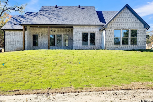 rear view of property featuring a lawn