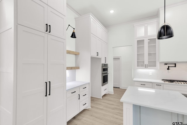 kitchen with light hardwood / wood-style floors, appliances with stainless steel finishes, white cabinetry, and pendant lighting