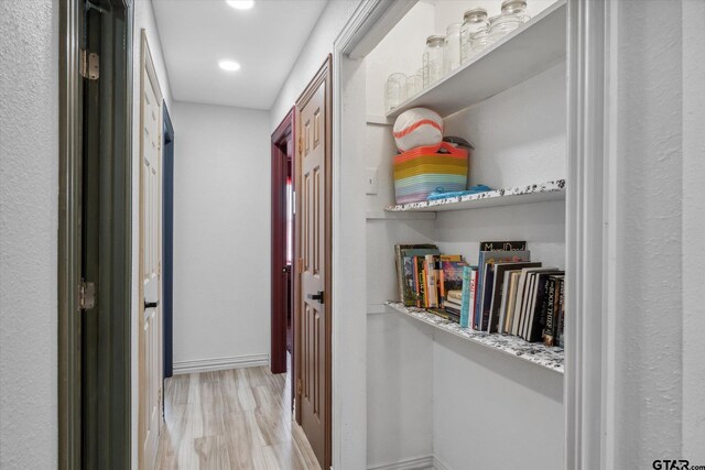 hallway with baseboards, light wood-style floors, and recessed lighting