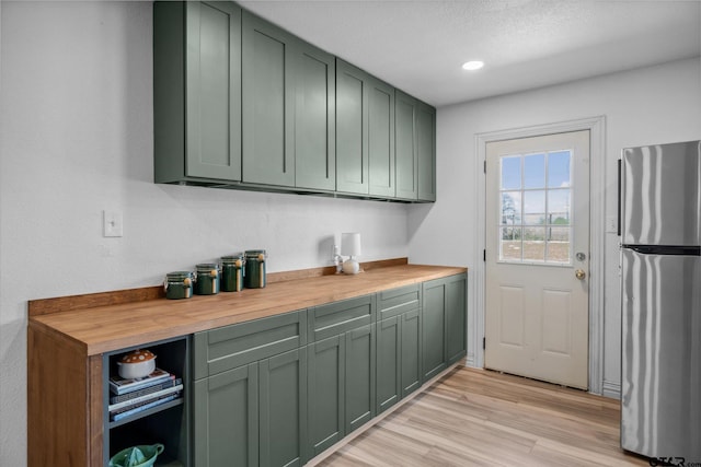 laundry area with light wood-style flooring and recessed lighting