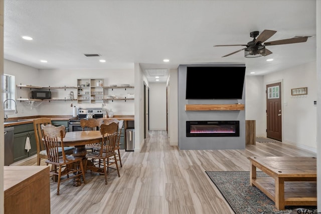 dining space featuring visible vents, ceiling fan, recessed lighting, light wood-style floors, and a glass covered fireplace