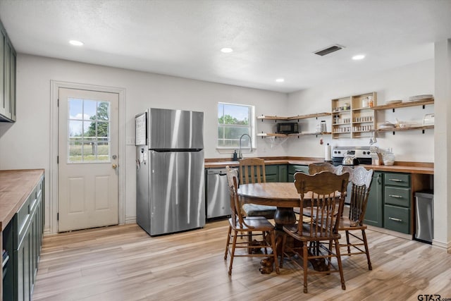 dining area with visible vents, light wood-style flooring, recessed lighting, and a textured ceiling