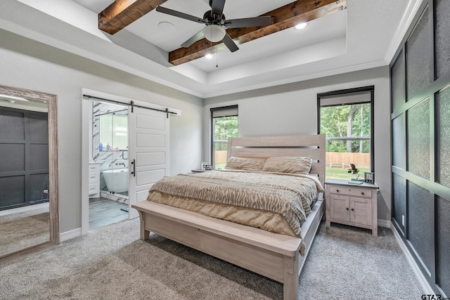 carpeted bedroom featuring ceiling fan, a barn door, multiple windows, and ensuite bath