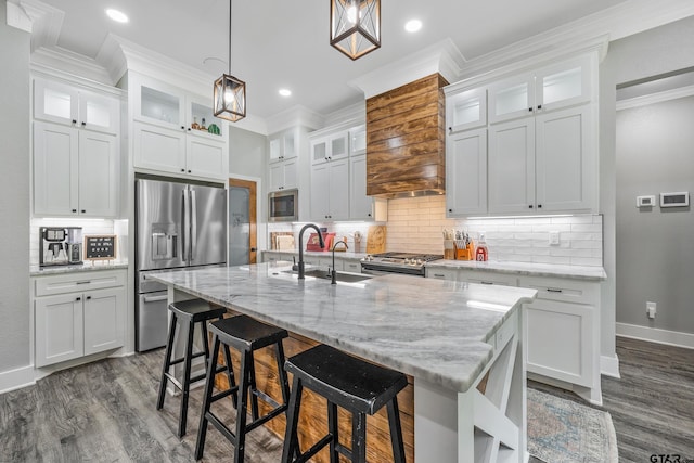 kitchen with white cabinetry, stainless steel appliances, and an island with sink