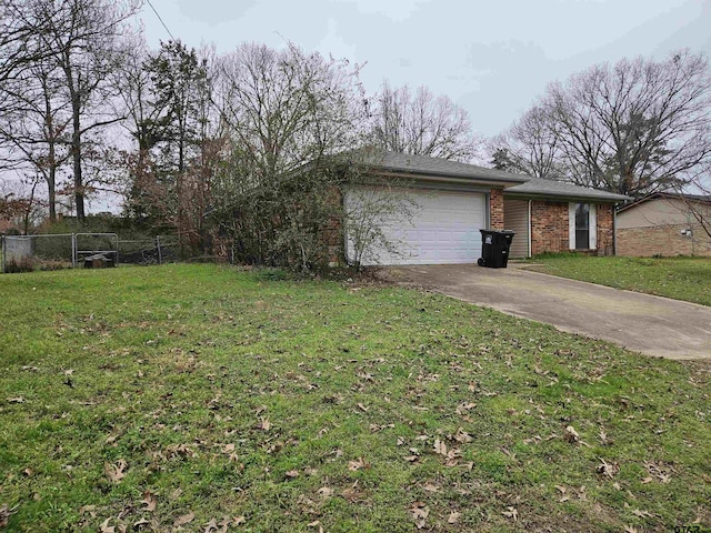 view of yard featuring a garage, driveway, and fence