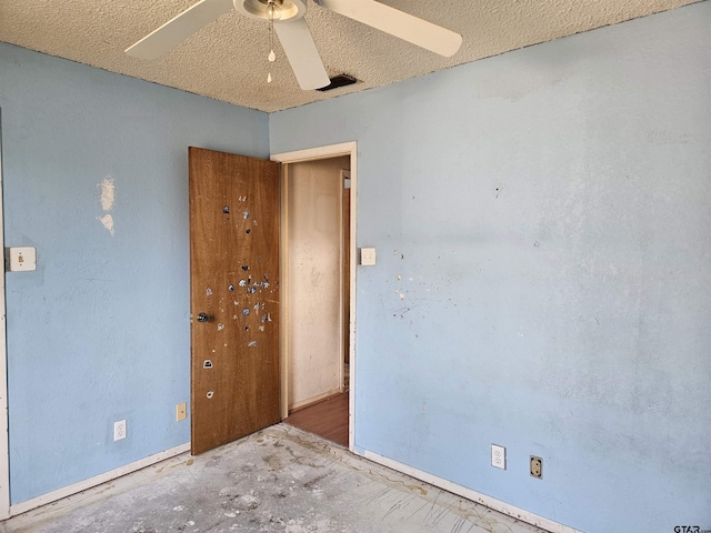 unfurnished room featuring a textured ceiling, a ceiling fan, and unfinished concrete floors