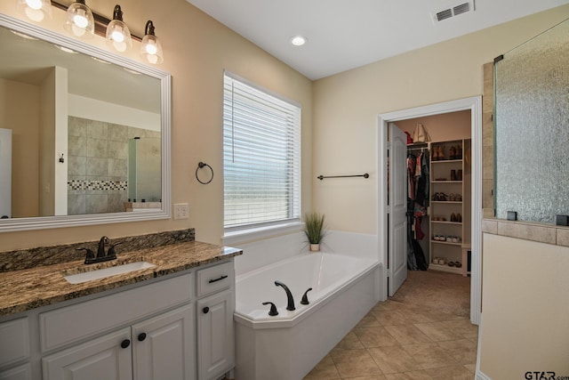 109 Nathan, Chandler, TX 75758 - full bath featuring vanity, a shower stall, a garden tub, a spacious closet, and tile patterned floors