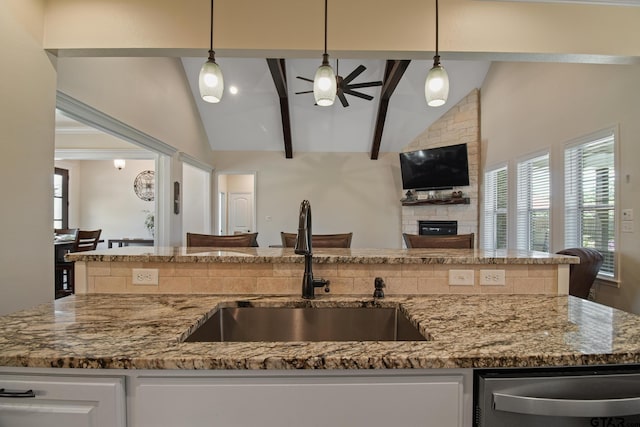 109 Nathan, Chandler, TX 75758 - kitchen with dishwasher, light stone counters, a stone fireplace, ceiling fan, and beam ceiling