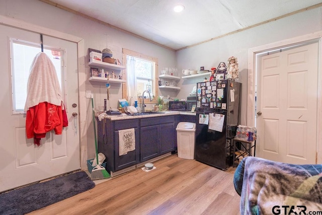 interior space with crown molding, freestanding refrigerator, light wood-style floors, recessed lighting, and a sink