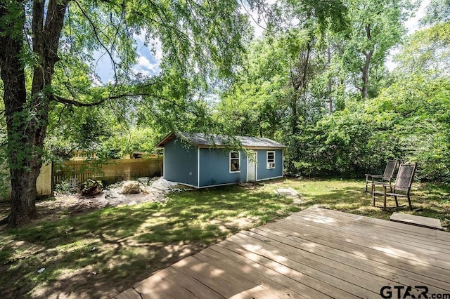 wooden deck featuring a yard, fence, and an outdoor structure