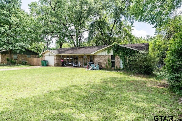 view of front of house featuring board and batten siding, brick siding, fence, and a front yard