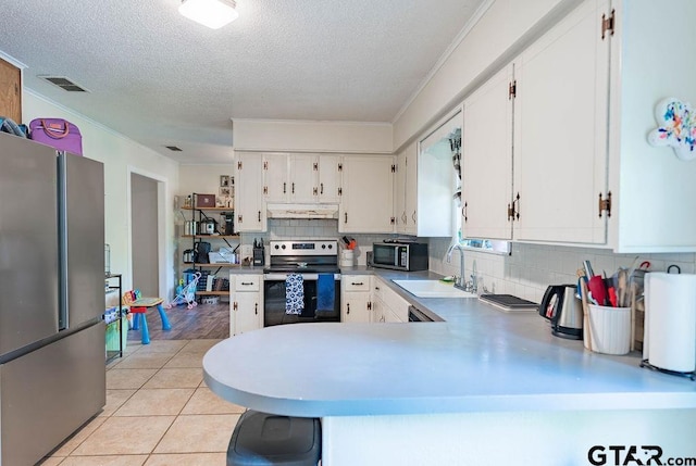 kitchen with backsplash, a textured ceiling, visible vents, under cabinet range hood, and stainless steel appliances