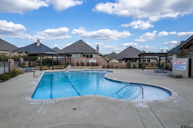 pool with a patio area, fence, and a pergola