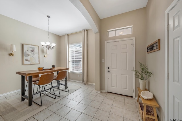 foyer with arched walkways, light tile patterned floors, baseboards, and an inviting chandelier