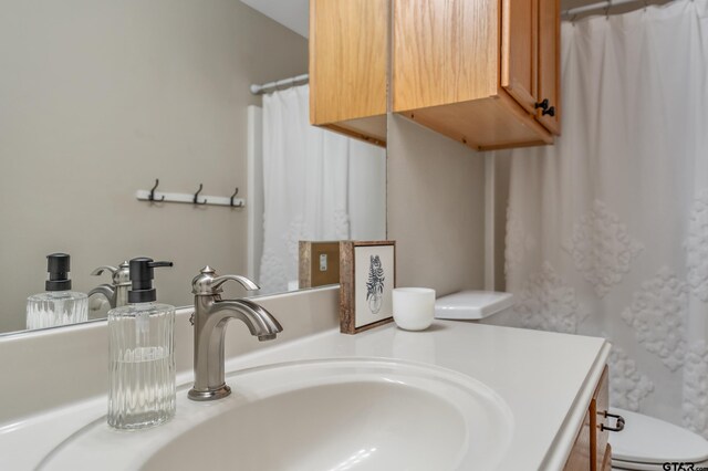 bathroom featuring curtained shower, vanity, and toilet