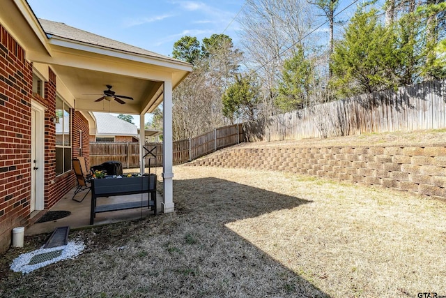 view of yard featuring a patio area, ceiling fan, and a fenced backyard