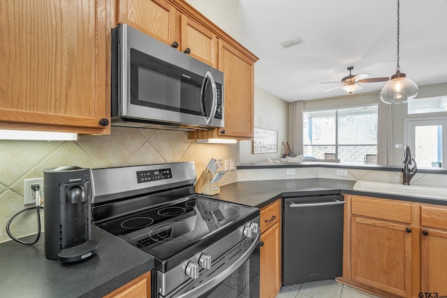 kitchen with tasteful backsplash, dark countertops, visible vents, appliances with stainless steel finishes, and a sink