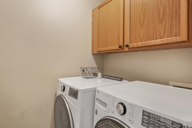 laundry area featuring washer and clothes dryer and cabinet space