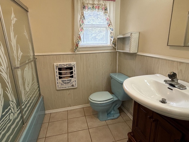 full bathroom featuring heating unit, vanity, tile patterned flooring, toilet, and combined bath / shower with glass door