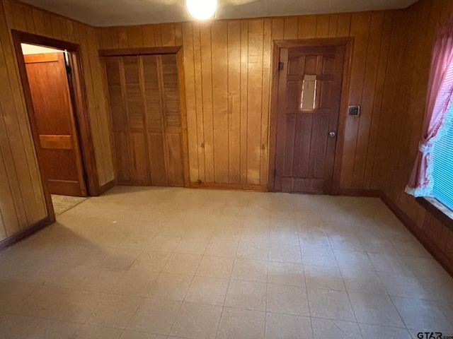 unfurnished room featuring wood walls