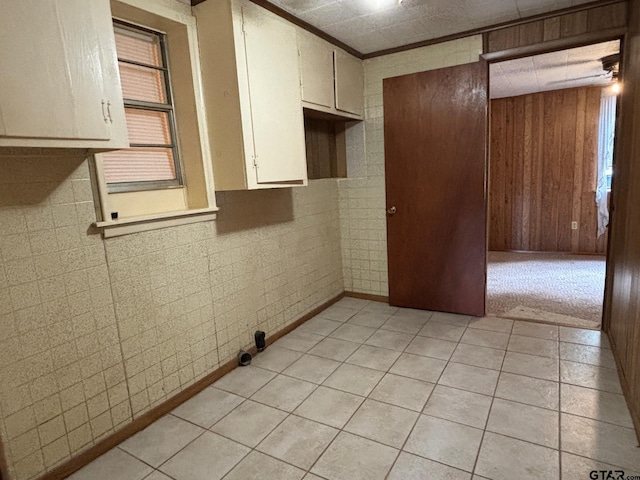 kitchen featuring tile walls, wood walls, and light tile patterned flooring